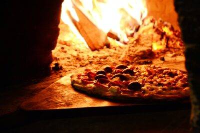 close up photo of pizza near bonfire
